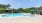 a swimming pool with a lounge chair and umbrellas