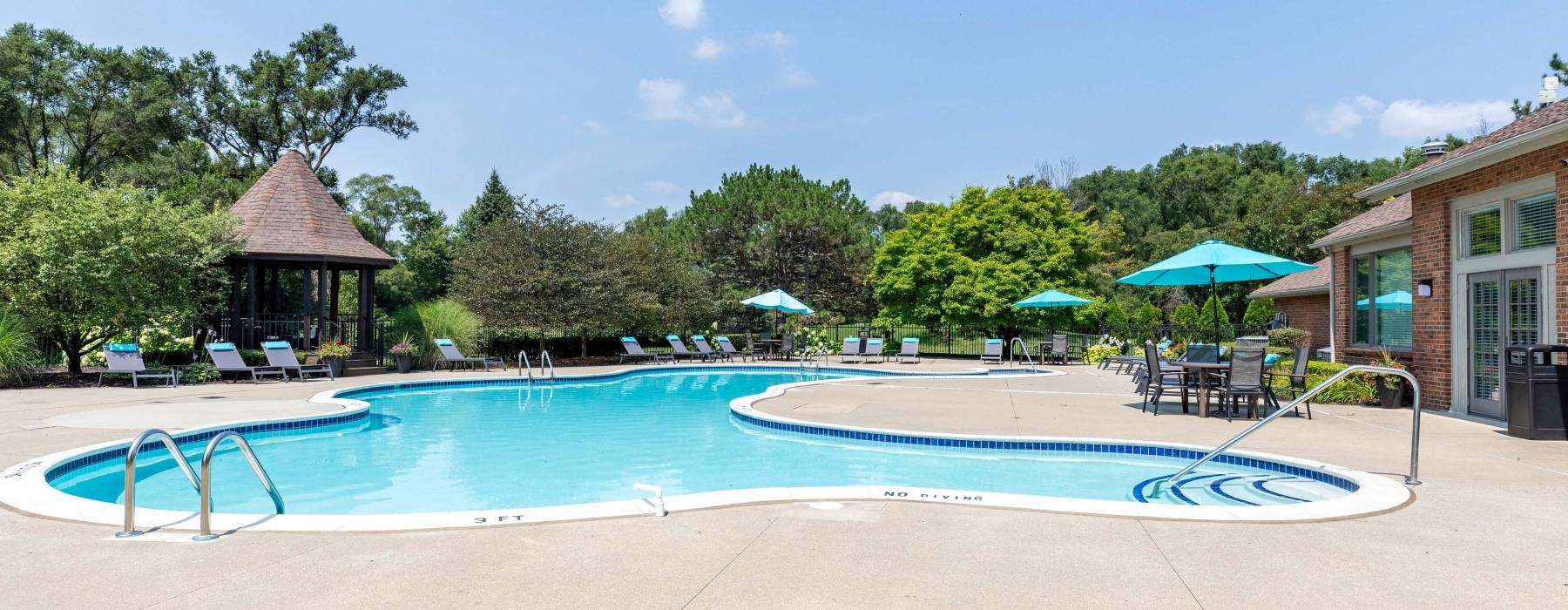 a swimming pool with a lounge chair and umbrellas